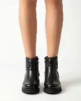 Bota corta de cuero color marrón, con diseño que combina cuero liso y sectores con textura grabada. Presenta una base robusta con taco medio y cierre lateral para facilitar el calce.