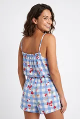 Conjunto de pijama de dos piezas confeccionado en tejido ligero con estampado de cuadros vichy en tonos celestes y blancos, complementado con un diseño de fresas y cerezas. El top es de tirantes finos con escote fruncido elástico, y el short cuenta con cintura elástica cómoda.