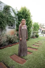 Vestido largo de encaje con mangas largas y cuello redondo. El vestido es de corte recto y tiene un forro interior.