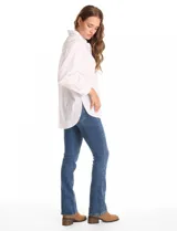 Camisa de corte oversize marca Grand & Greene, confeccionada en una mezcla de tencel, poliéster y elastano. Presenta cuello con solapa, cierre frontal con botones, mangas largas con hombros caídos y puños con botón. Incluye un bolsillo en el pecho, canesú trasero con tablón central y un bajo redondeado asimétrico, siendo más largo en la parte posterior.