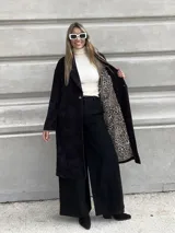 Tapado largo de corderoy negro con forro animal print de leopardo, corte recto y solapas.