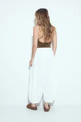 Pantalón ancho estilo Aladdin de tiro bajo, color marrón rojizo, con cintura elastizada y puños ajustados en los tobillos.