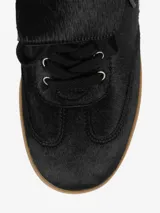Zapatillas negras con cuña oculta, parte superior de cuero y suela de goma color caramelo.