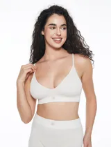 Top deportivo de estilo bralette, confeccionado en tejido seamless acanalado de color verde militar. Presenta breteles finos ajustables, escote en V y una banda elástica inferior con una pequeña etiqueta decorativa central.