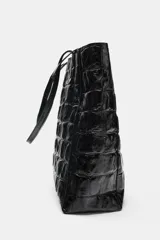 Bolso tipo shopper de cuero en color bordó con textura y estampado tipo cocodrilo. Cuenta con doble asa de hombro y un compartimento principal amplio con bolsillo interior.