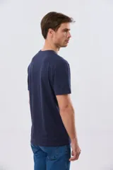 Remera azul marino de manga corta con cuello redondo, confeccionada en mezcla de algodón y poliéster. Presenta un estampado frontal circular de inspiración vintage con diseño de velero y tipografía alusiva a clubes deportivos.