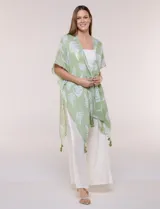 Kimono de gasa verde con estampado de hojas blancas y detalles de lurex. Presenta mangas cortas holgadas, diseño abierto al frente y terminación en punta con borlas en el ruedo.