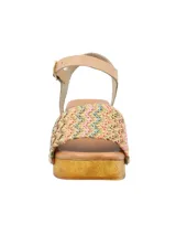 Sandalia de taco alto tipo zueco con plataforma de madera, capellada de rafia tejida multicolor, tira de ajuste al tobillo en cuero color tostado y tachas metálicas decorativas.
