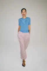 Pantalón bombacho de tiro medio, confeccionado en mezcla de algodón con estampado de cuadros en tonos rosados y oscuros. Presenta cintura elástica y bajo abullonado con puño elástico.