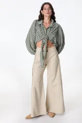 Blusa negra con escote en V, mangas largas abullonadas y lazo para atar en la parte delantera.