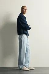 Pantalón de jean corte recto desde la cadera hasta el tobillo, con tiro medio y tejido rígido. Presenta diseño de cinco bolsillos, cierre frontal con botones y acabado en efecto lavado claro.