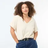 Camiseta de tejido crepé color beige, con escote en V y mangas cortas con dobladillo.