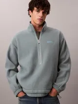 Buzo polar de Calvin Klein con cuello alto y cierre de media cremallera frontal. Presenta un diseño de manga larga con puños elásticos y un parche con el logo de la marca en el pecho.