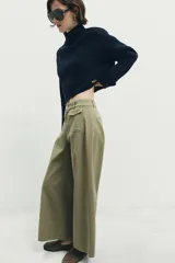 Pantalón culotte de tiro alto en color verde militar. Presenta bolsillos frontales de plastrón con solapa, cierre frontal con cremallera y botón, y diseño de pierna ancha con dobladillo marcado.