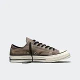 Championes Converse Chuck 70 de corte bajo, confeccionados en lona de color gris con estampado de estrellas. Presentan cordones negros, puntera de goma reforzada y entresuela barnizada en tono blanquecino con líneas negras decorativas.