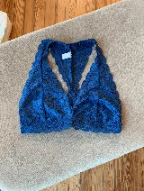 Soutien tipo bralette negro de encaje con diseño floral, espalda estilo nadador y elástico en el bajo busto para sujeción.