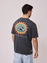 Remera color crema de corte holgado con estampado circular en el pecho.