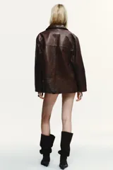 Chaqueta de cuero vacuno con acabado efecto lavado, cuello solapa, cierre frontal con botones y bolsillos delanteros con solapa. Presenta un corte recto y forro interior.