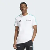 Remera blanca de algodón con cuello redondo y mangas cortas. Presenta tres tiras celestes en los hombros, logo de Adidas y logo de Mercedes AMG Petronas en el pecho.