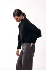 Chaqueta tejida de silueta recta con botones frontales y mangas tres cuartos terminadas en puños de piel sintética suave. Diseño versátil que permite usarla con los botones hacia adelante o hacia atrás.