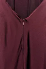 Vestido largo de satén en color bordó, con cuello halter y detalle de lazada en el cuello. Presenta un diseño fluido con espalda descubierta.