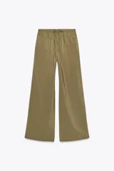 Pantalón tipo palazzo de corte recto y tejido fluido, color naranja. Presenta cintura elástica con cordón ajustable y bolsillos laterales.