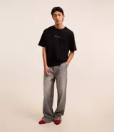 Remera negra de algodón, corte boxy, con cuello redondo y mangas cortas. Estampa frontal con el logo de Guns N' Roses en color dorado.