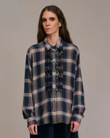 Camisa a cuadros azul, beige y marrón con cuello clásico, mangas largas y volantes en el frente.