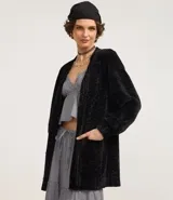 Cardigan largo de chenille con textura acanalada, manga larga y bolsillos delanteros. Presenta un diseño abierto y versátil, ideal para diversas ocasiones.