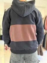 Hoodie de felpa con capucha y medio cierre frontal, diseño en bloques de color celeste y blanco, con bordados decorativos en el pecho.