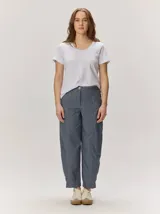Pantalón de lino color blanco crudo, de corte barrel, con bolsillos laterales y costuras pespunteadas a contratono.