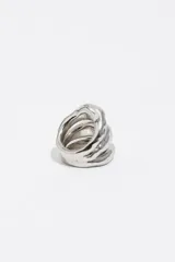 Anillo triple de diseño orgánico con acabado metálico plateado y un cristal central engastado.