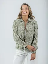 Camisa color crema con bordados florales, de corte recto y mangas largas.