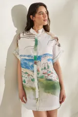 Vestido corto de lino blanco con estampado artístico de paisaje costero, cuello mao y mangas cortas holgadas.