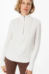 Sweater de punto gris con textura de ochos, cuello alto con cierre frontal parcial, manga larga y puños y ruedo acanalados.