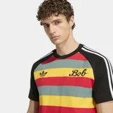 Remera Adidas Originals de corte ajustado con diseño de rayas horizontales en colores rojo, amarillo y verde. Presenta mangas cortas negras con las icónicas tres tiras blancas en los hombros, cuello redondo negro, logo del trébol bordado en el pecho y la inscripción 'Bob' en tipografía cursiva.