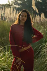 Conjunto de dos piezas color borgoña de tejido acanalado, compuesto por un cárdigan corto con botones y mangas largas con aberturas, y un pantalón palazzo de tiro alto.