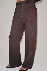 Pantalón cargo de tiro medio con efecto lavado, confeccionado en algodón. Presenta cintura elástica ajustable con cordones, bolsillos laterales y bolsillos de plastrón con solapa en las piernas. Diseño de pierna recta con combinación de tejidos a tono.