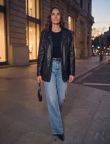 Blazer de eco cuero negro, con solapa clásica, cierre frontal con botones y bolsillos aplicados.