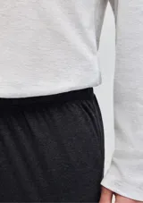 Pijama compuesto por una remera de manga larga con cuello en V y un pantalón largo de corte recto. La remera es de color gris claro con detalles de líneas oscuras en el cuello y el pecho, mientras que el pantalón es de color gris oscuro.