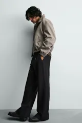 Cazadora cropped de hombre con tejido de estructura espiga. Presenta cuello subido con cierre de botones, cierre frontal de cremallera, bolsillos laterales con solapa y acabados elásticos en puños y cintura.