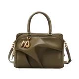 Cartera tipo bauletto de Marc Jacobs, confeccionada en cuero de cordero color verde oliva. Presenta un diseño estructurado con detalles drapeados en el frente, asas superiores y una correa de hombro ajustable y extraíble. Incluye herrajes metálicos dorados y un dije decorativo en la parte frontal.
