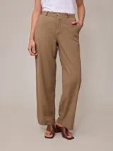 Pantalón de lino color tostado, de corte recto y tiro alto, con trabillas para cinto y bolsillos laterales.
