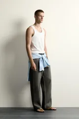 Camiseta sin mangas tipo tank top de corte slim fit, confeccionada en tejido de algodón con elasticidad, cuello redondo amplio y vivos en tejido combinado a tono.