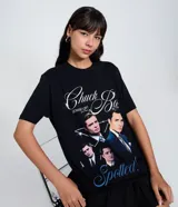 Remera negra de algodón con cuello redondo y mangas cortas. Presenta un estampado gráfico frontal con imágenes de Chuck Bass de la serie Gossip Girl y lettering decorativo.