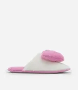 Pantufla abierta de diseño fluffy, confeccionada en poliéster suave de color blanco con una aplicación de corazón en relieve de color rosado. Cuenta con suela de goma termoplástica antideslizante y plantilla en tono rosado.