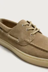 Mocasines estilo náutico de piel con acabado serraje, en color tostado, con cordones y suela de goma a contraste.