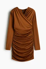 Vestido mini de manga larga en punto elástico con escote cruzado en V. Modelo de corte ajustado con frunces en hombros y laterales para crear un efecto drapeado.
