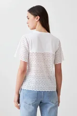 Remera fucsia de manga corta con detalle de broderie en las mangas.