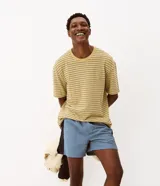 Remera boxy de manga corta y cuello redondo para hombre, confeccionada en algodón con textura y diseño de rayas horizontales en color amarillo y negro.